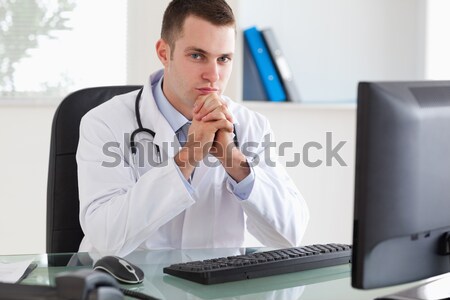 Stock photo: Young doctor looking at X-ray in her office