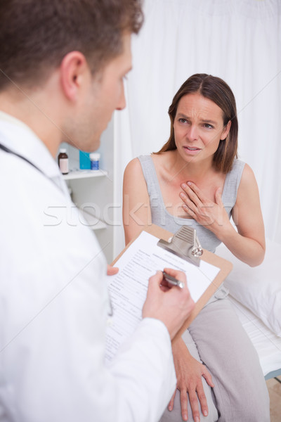 Stock photo: Patient talking to doctor about her symptoms