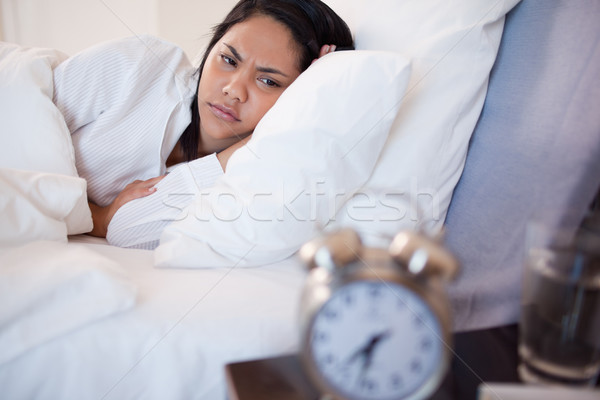 Side view of young woman being woken by alarm clock Stock photo © wavebreak_media