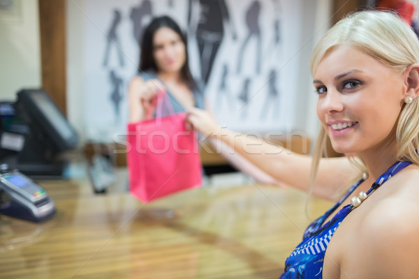 Woman taking purchases at chas register in clothing store Stock photo © wavebreak_media