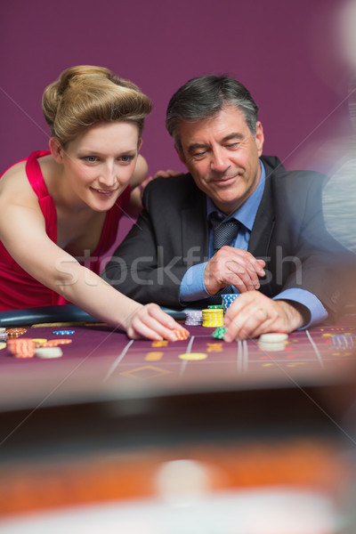Woman and man placing bets at roulette table Stock photo © wavebreak_media