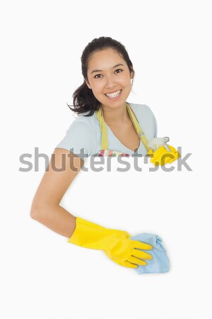 Smiling woman in rubber gloves and apron wiping down white surface Stock photo © wavebreak_media