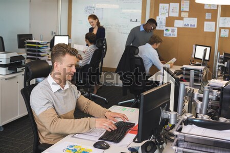 Stock photo: Man looking up from computer class and smiling
