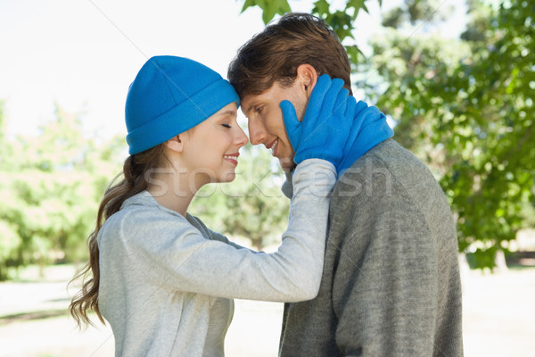 Stock photo: Cute couple standing in the park in hats and scarves