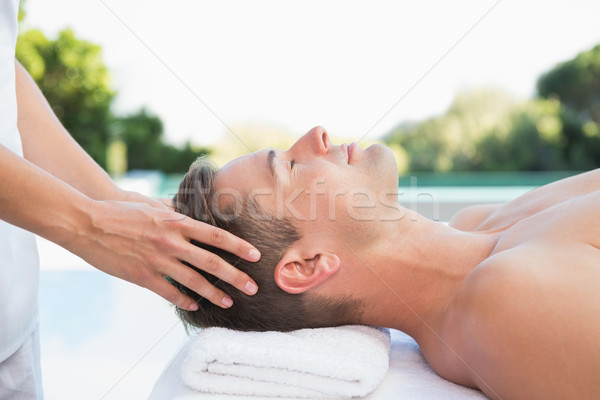 Stock photo: Peaceful man getting a head massage poolside