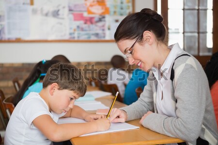 Pretty teacher helping pupil in classroom Stock photo © wavebreak_media