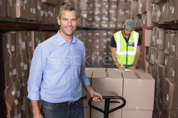 Warehouse manager smiling at camera with trolley Stock photo © wavebreak_media