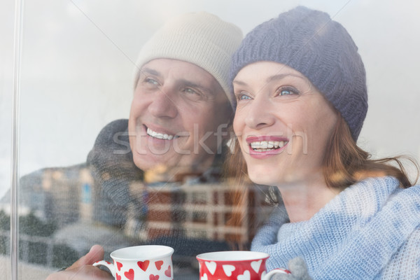 Happy couple in warm clothing holding mugs Stock photo © wavebreak_media