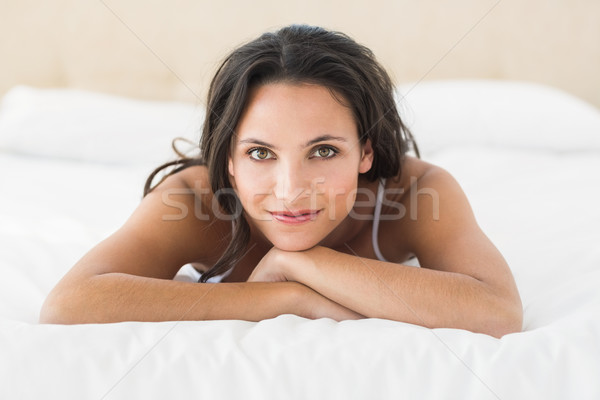 Happy brunette lying on bed Stock photo © wavebreak_media