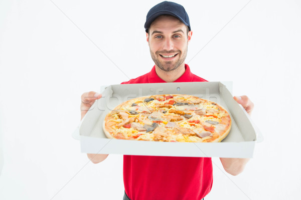 Happy delivery man showing fresh pizza Stock photo © wavebreak_media