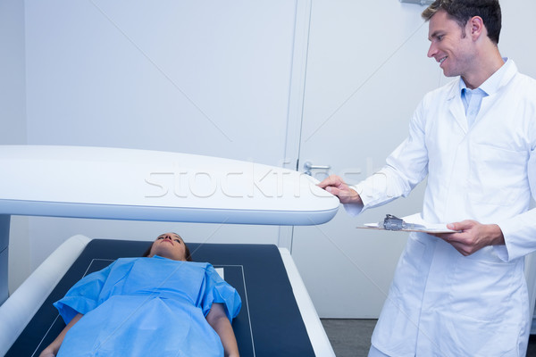 Smiling doctor proceeding a radiography on a patient Stock photo © wavebreak_media