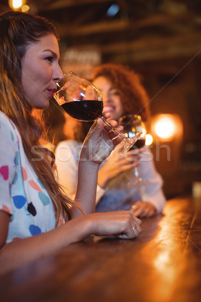 Doua femeile tinere vin rosu pub frumos femeie Imagine de stoc © wavebreak_media