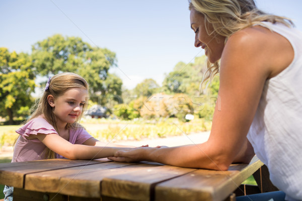 Mother and daughter holding hands on picnic table Stock photo © wavebreak_media