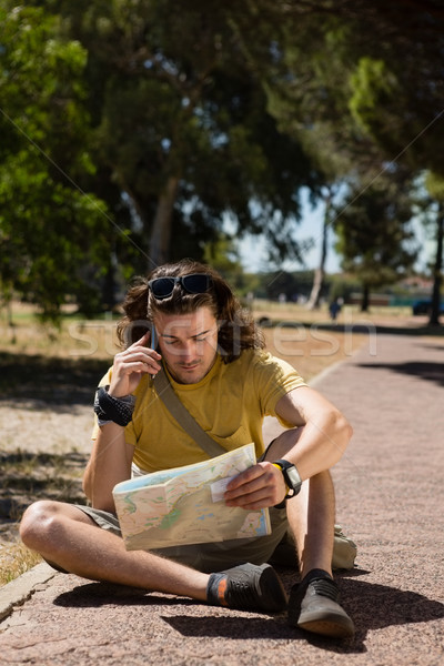 Turista homem mapa falante telefone móvel parque Foto stock © wavebreak_media
