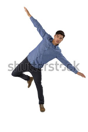 Stock photo: Full length of businessman with arms outstretched balancing while standing