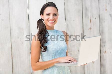 Student on laptop against white tiling Stock photo © wavebreak_media