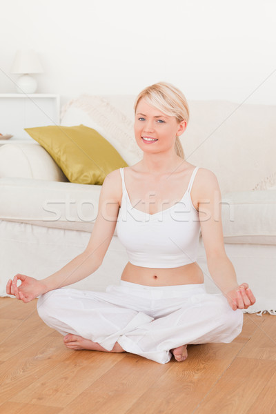 Young beautiful female doing yoga in the living room in her appartement Stock photo © wavebreak_media