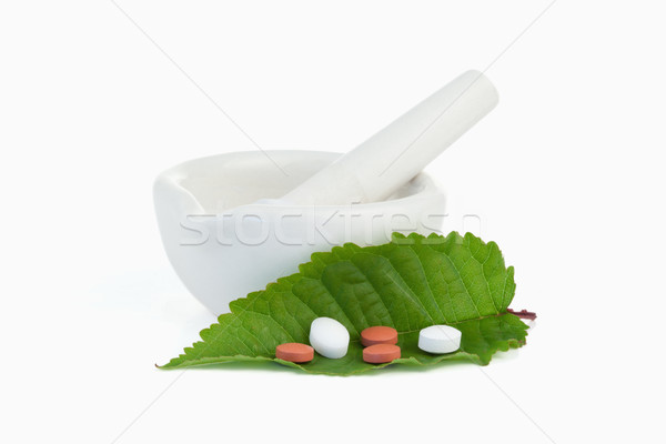 Mortar and pestle with pills on a leaf against a white background Stock photo © wavebreak_media