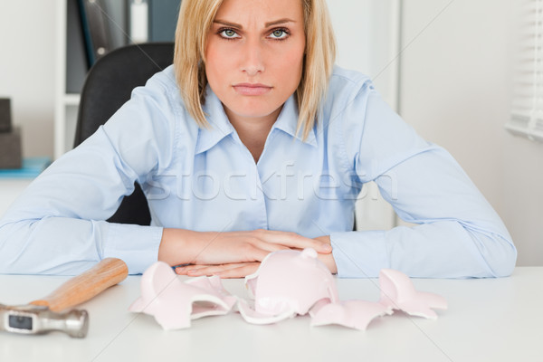Sad woman sitting in front of an empty shattered piggy bank in her office Stock photo © wavebreak_media