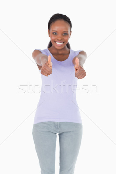 Close up of thumbs up being given by smiling woman on white background Stock photo © wavebreak_media
