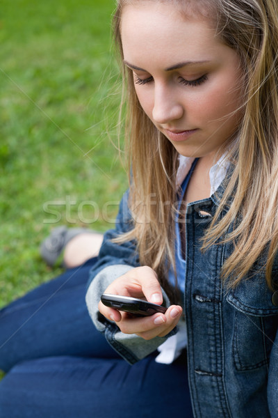 年輕的女孩 文本 手機 坐在 草 商業照片 © wavebreak_media