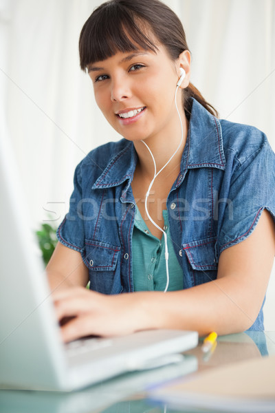 Portrait of a female student doing her homework on her laptop  with music Stock photo © wavebreak_media