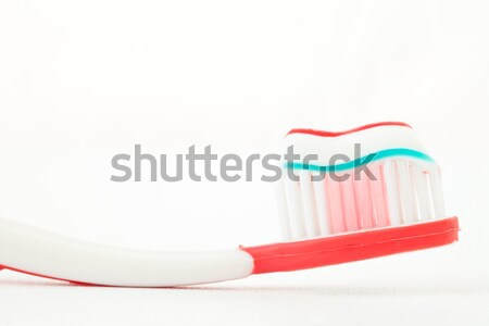 Red toothbrush with toothpaste against white background Stock photo © wavebreak_media