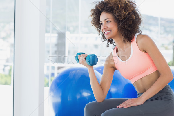 Smiling young woman exercising with dumbbell in gym Stock photo © wavebreak_media