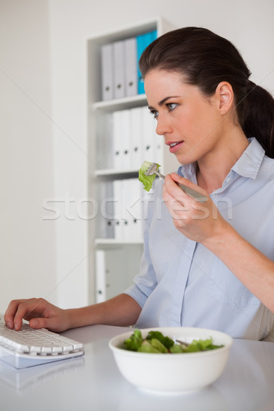 Casual morena mujer de negocios comer ensalada escritorio Foto stock © wavebreak_media