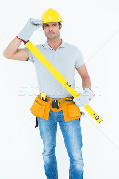 Carpenter holding spirit level while wearing hard hat Stock photo © wavebreak_media