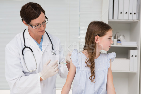 Stock photo: Doctor doing injection at a little girl 