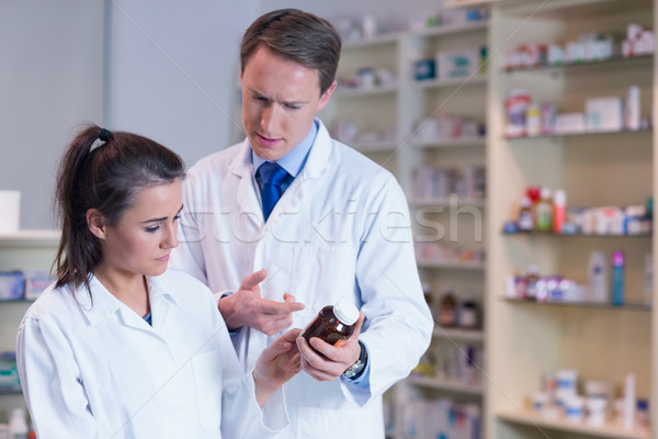 Stock photo: Pharmacist showing medication to his trainee