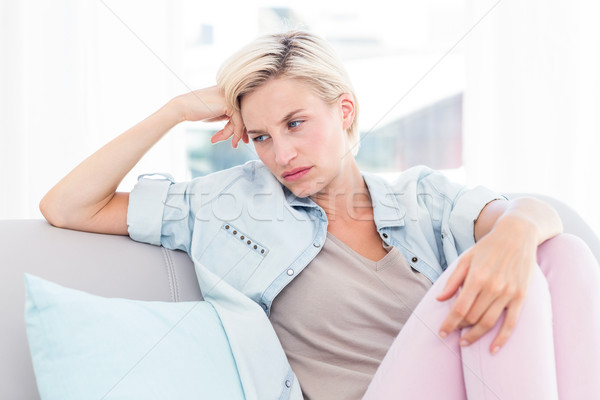 Thoughtful blonde woman sitting on the couch Stock photo © wavebreak_media