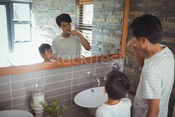 Father and son brushing teeth together in bathroom Stock photo © wavebreak_media