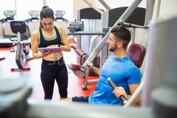 Trainer working with athlete at weights machine Stock photo © wavebreak_media