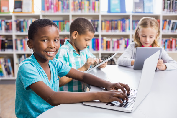 Kinderen met behulp van laptop digitale tablet bibliotheek school Stockfoto © wavebreak_media