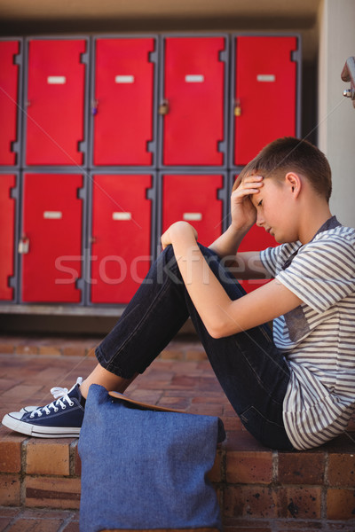 Szomorú iskolás fiú ül lépcsőház iskola fiú Stock fotó © wavebreak_media