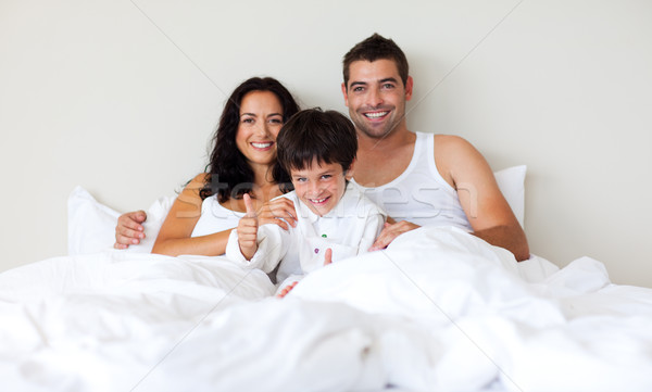 Kid with thumbs up and his parents in bed Stock photo © wavebreak_media