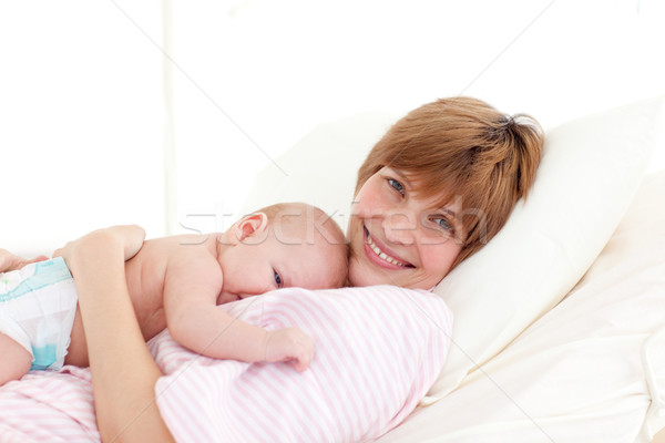 Mother with newborn baby in bed smiling at the camera Stock photo © wavebreak_media