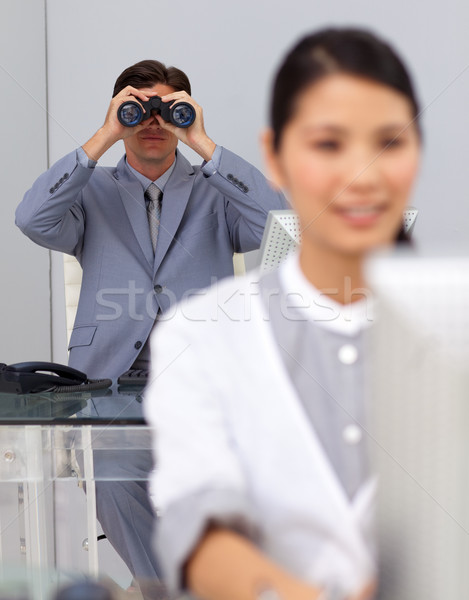 Visionary businessman using binoculars with his colleague working in the foreground Stock photo © wavebreak_media