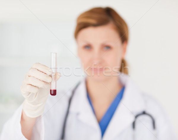 Female scientist looking at the camera while holding a red test tube in a lab Stock photo © wavebreak_media