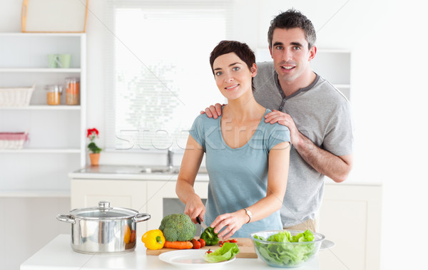 Husband massaging his wife while she is cutting vegetables in a kitchen Stock photo © wavebreak_media