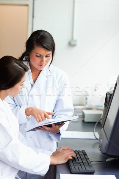 Stock photo: Portrait of serious scientists looking at a report in a laboratory