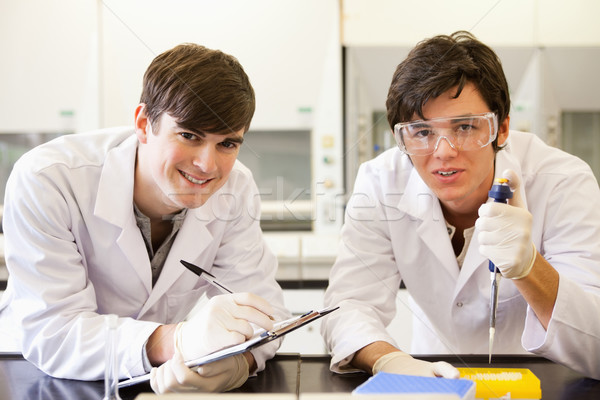 Handsome scientists making an experiment while looking at the camera Stock photo © wavebreak_media