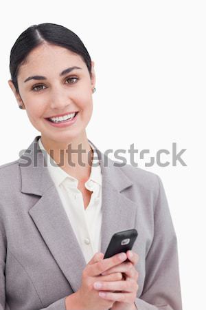 Close-up of a businesswoman smiling and holding her mobile against white background Stock photo © wavebreak_media