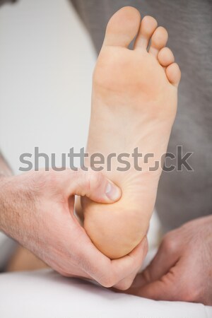 Thumbs of a doctor massaging a foot in a room Stock photo © wavebreak_media