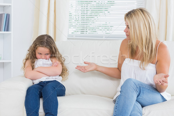 Stock photo: Angry mother sitting with her daughter on the sofa in the living room