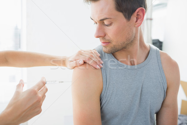 Doctor injecting man on arm in hospital Stock photo © wavebreak_media
