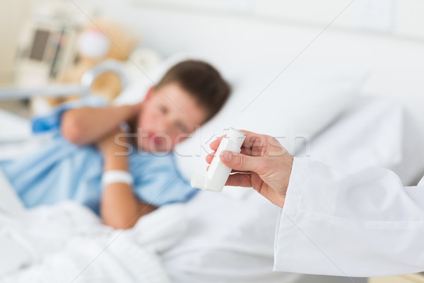 Doctor holding asthma inhaler with boy in hospital Stock photo © wavebreak_media