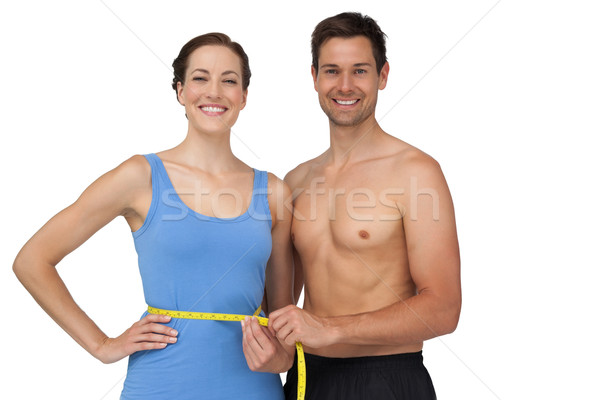 Fit young man measuring womans waist Stock photo © wavebreak_media